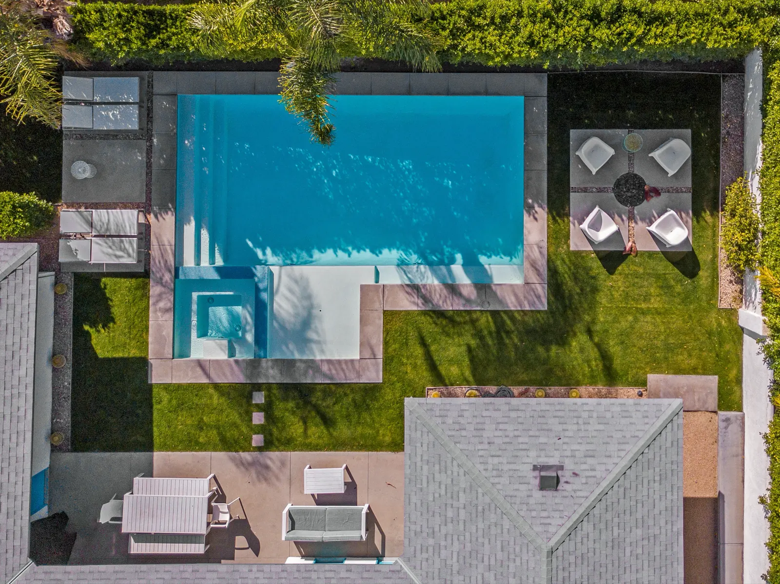 Aerial view of a backyard pool with spa and lounge area