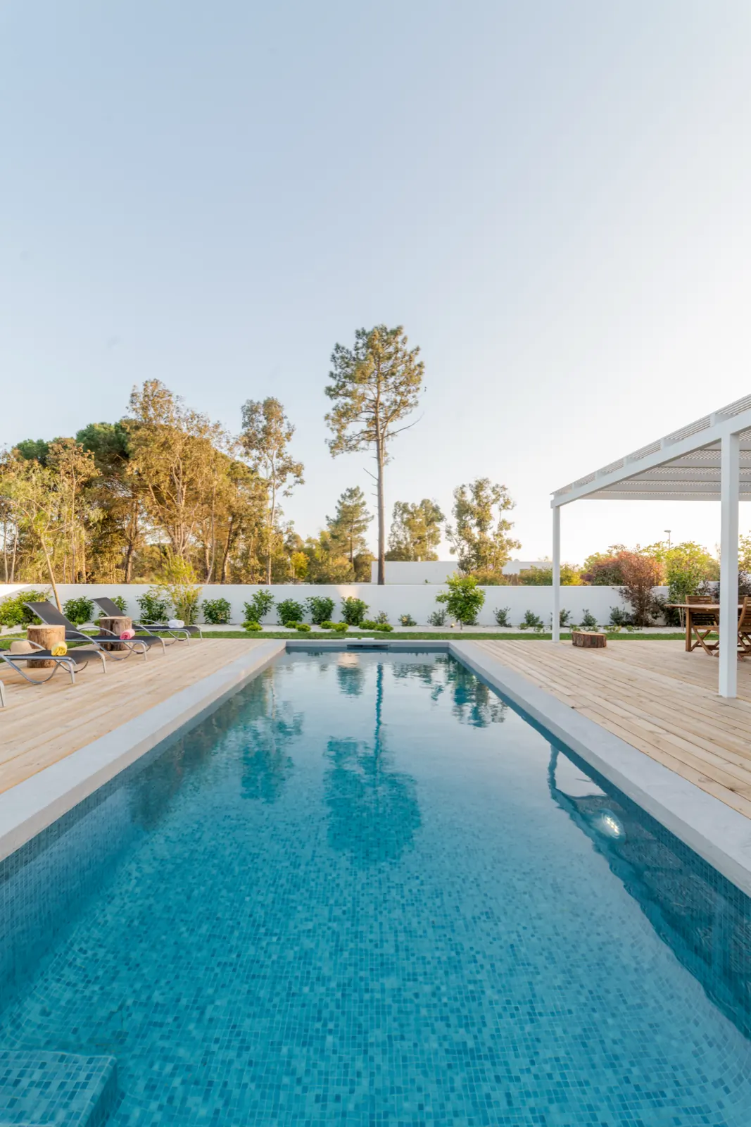 Long pool with wood deck and pergola