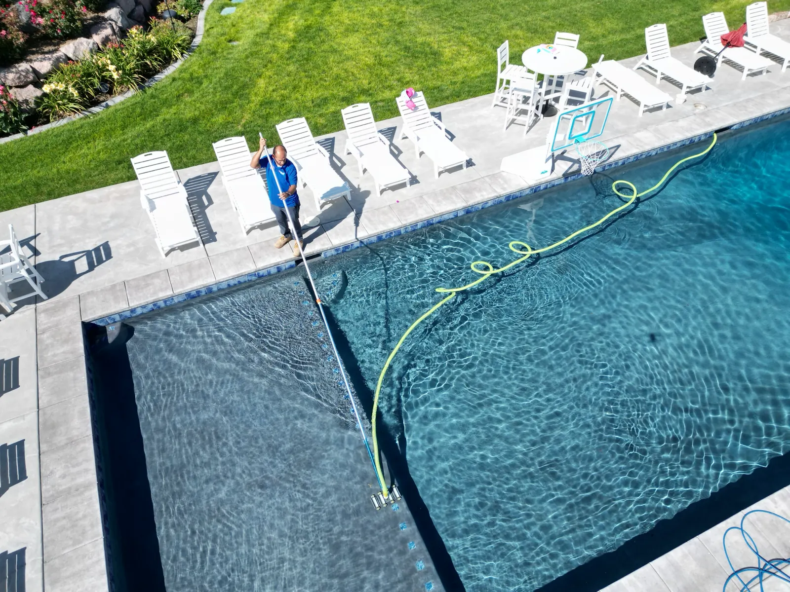 Overhead view of a technician vacuuming a pool