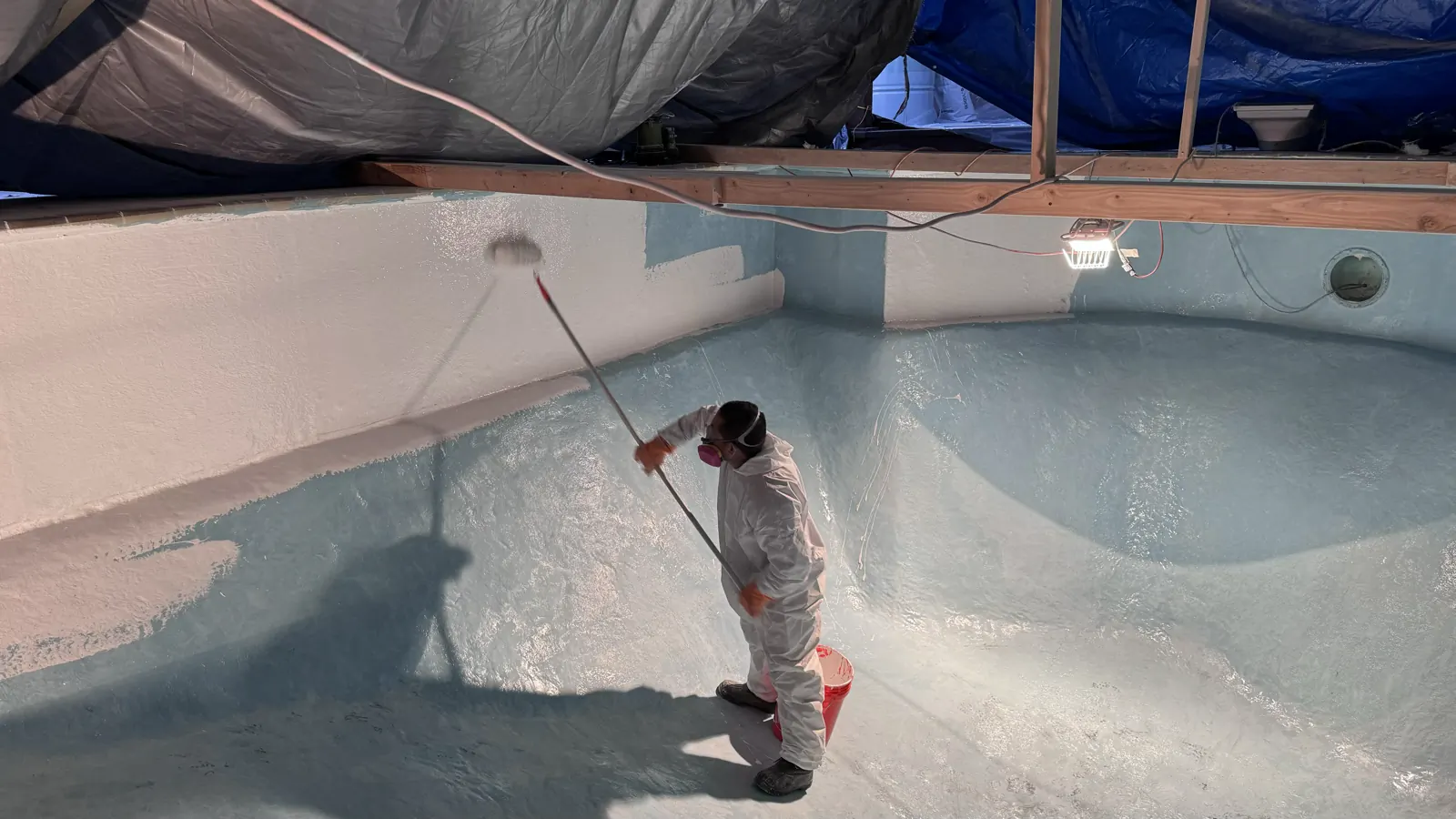 Technician applying a new finish coat to a pool